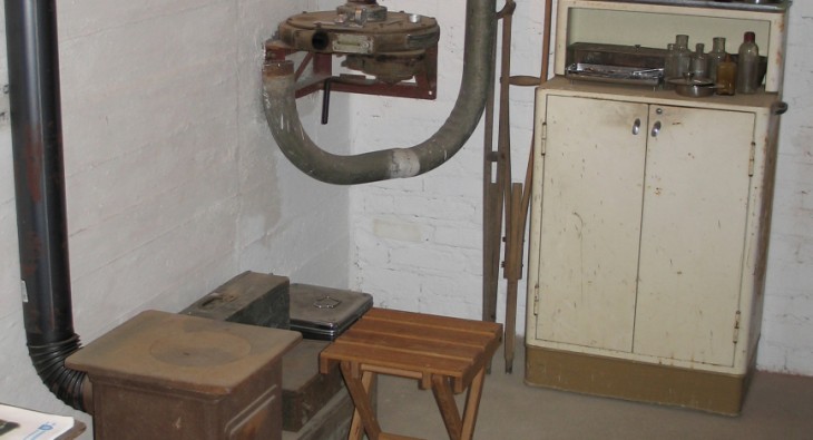 Kellerartiger Raum mit einem alten Schrank und verschiedenen Rohren