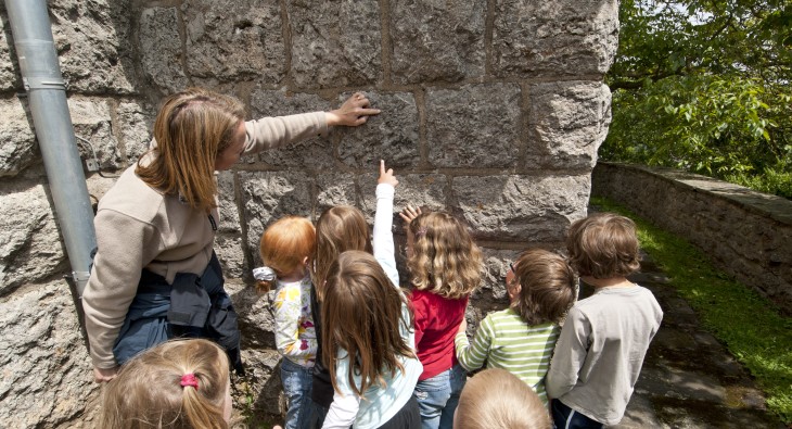 Kinder suchen nach Fossilien in einer Mauer